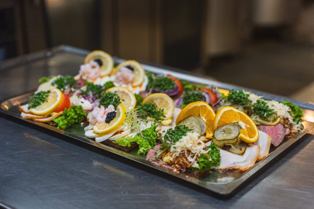 Appetitvækkende anretning af klassisk højtbelagt smørrebrød fra Det Gode Køkken i Odense, herunder fiskefilet med remoulade, roastbeef og æg med rejer.